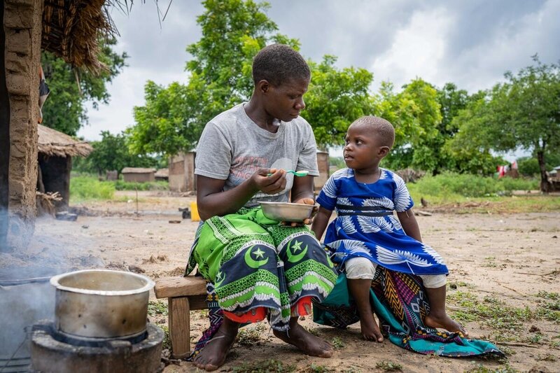 Vimvi school – Chikwawa district. Mary Size and her daughter Margarete cooking and eating porridge. 
A lot of children’s parents affected by cyclone Ana 
River flooded the fields. 
Houses fell down
Food items destroyed
fear that drop out will increase 
each parent getting 5 kg of CSB.
700 children in the school – 35,000 targeted in total 
Thanks to EU

On 25 January 2022, much of central and southern Malawi fell within the storm path of tropical storm Ana.  Severe flooding has damaged people’s lives, livelihoods, socio-economic infrastructure, and key supply routes and bridges. The Government of Malawi officially declared a state of disaster.  Official figures indicate approximately 995,000 people have been affected in some 18 districts throughout the country. This figure is similar to the number of damage and affected people registered in 2019 after Cyclone Idai. 

The overall impact of the floods on food security is significant, as many have lost nearly all their productive assets and remaining food commodities. Heavy rains and floods have impacted agricultural activities, fields are inundated and recently-planted crops have been destroyed.   

As part of our immediate response, WFP has provided corn soya blend to some 95,000 people in the four most affected districts of Chikwawa, Mulanje, Nsanje and Phalombe. Corn soya blend is a nutritive porridge made of soya and maize and fortified with vitamins and minerals. Each household received a 12kg ration to prevent undernutrition, meeting energy requirements for one week.  WFP also continues to provide common logistics services to the Government and other humanitarian partners for the transport and handling of essential relief items.